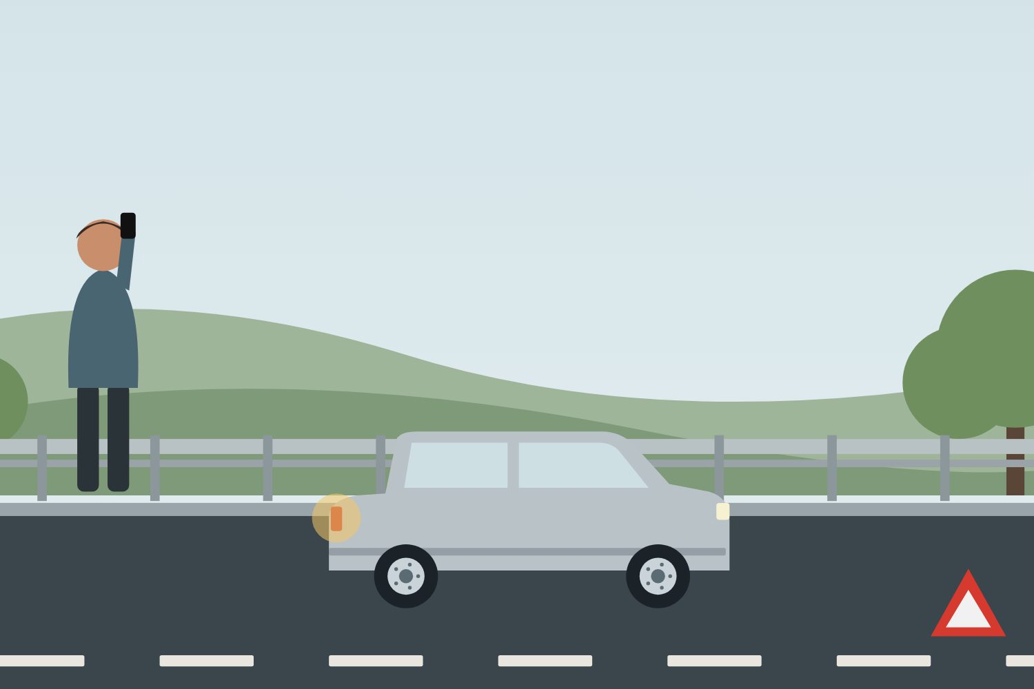 Driver phoning for recovery beside a car with hazard lights